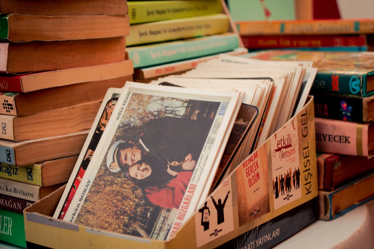 gallery-4 A collection of vintage books and postcards in a cozy library setting, showcasing a love for literature.